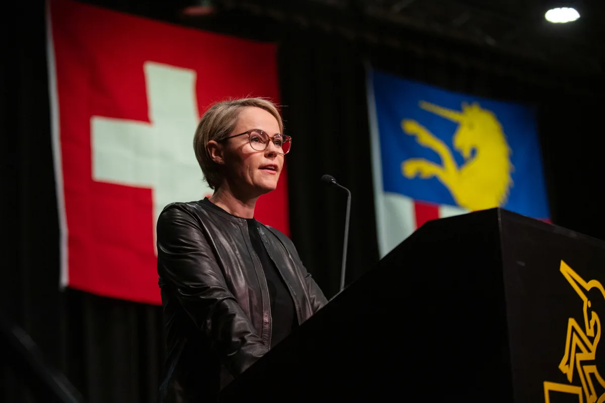 Eine Frau steht an einem Rednerpult und spricht. 